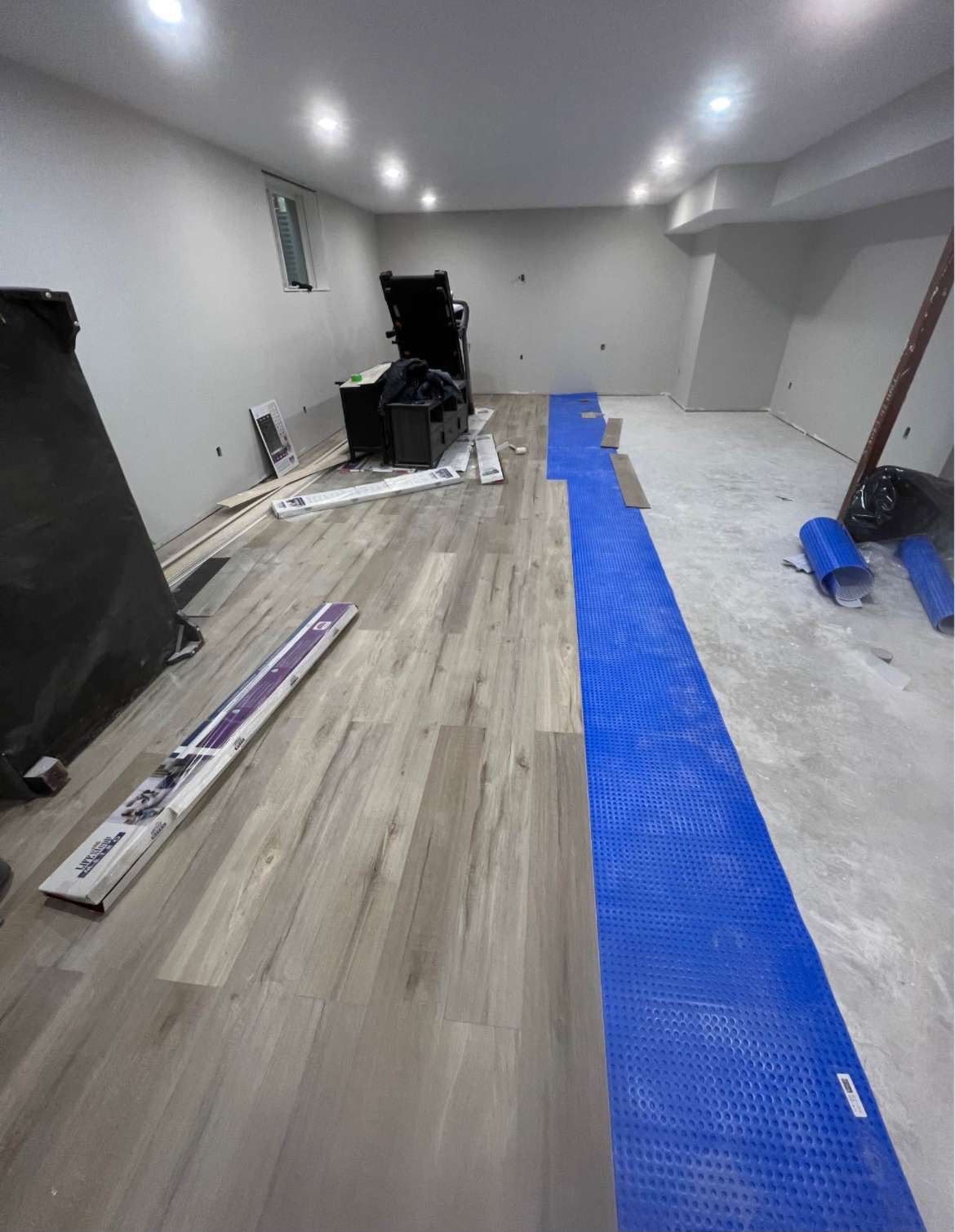 Vinyl plank flooring being installed in a basement